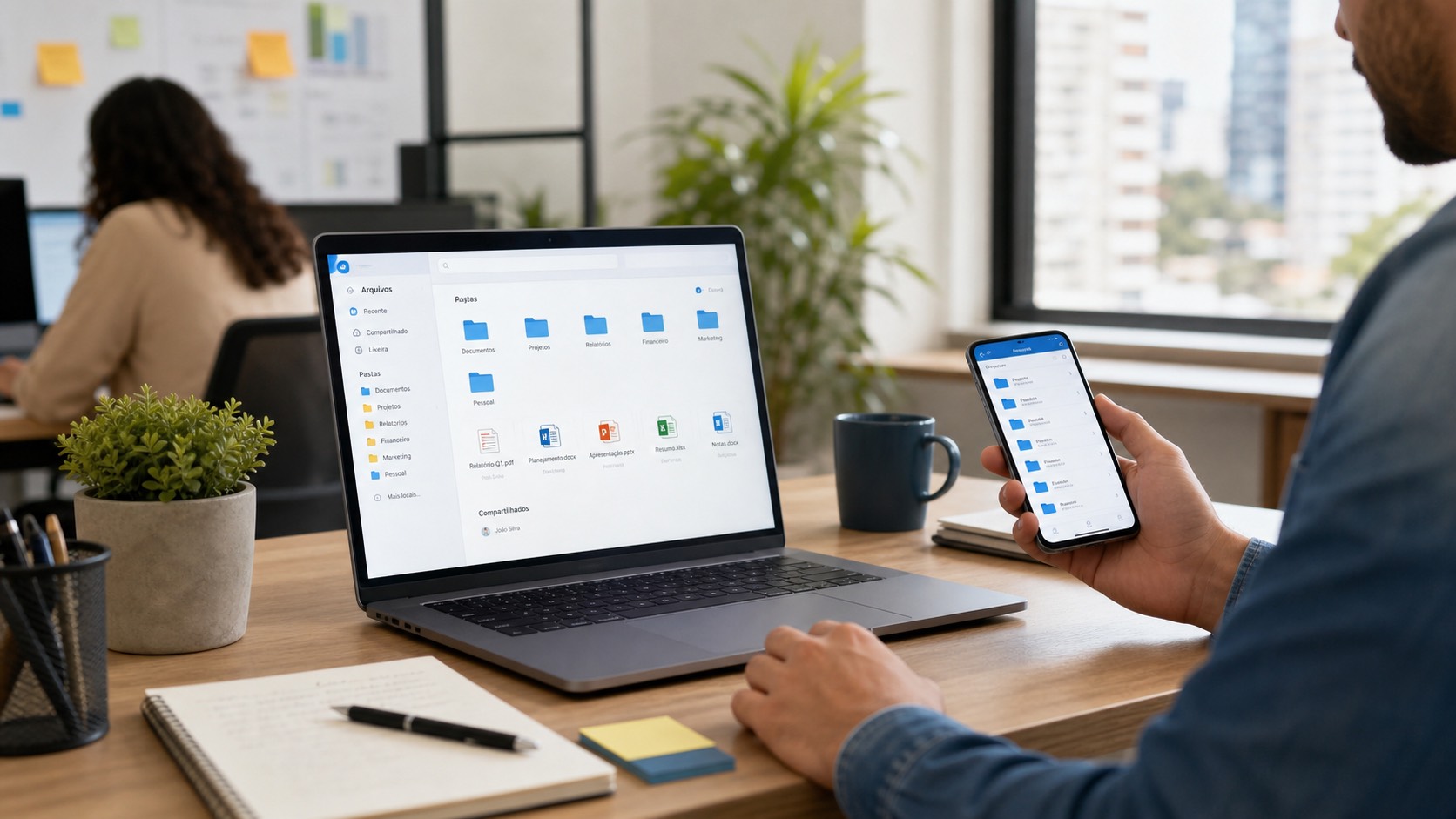 Profissional usando OneDrive para organizar arquivos da empresa em laptop e celular